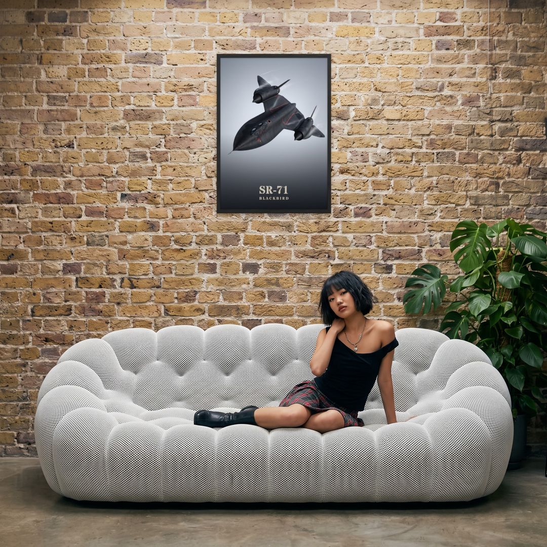 SR-71 Blackbird, framed in black, in an industrial loft with tufted sofa