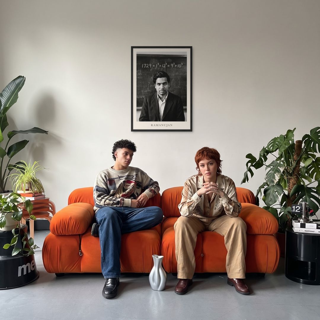 Srinivasa Ramanujan, framed in black, in a retro orange sofa lounge