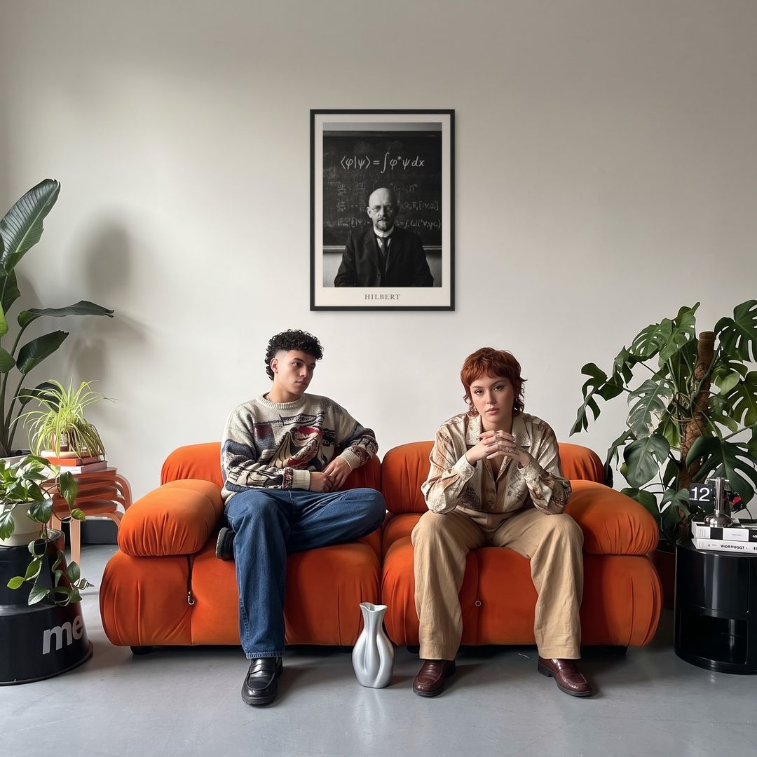 David Hilbert, framed in black, in a retro orange sofa lounge