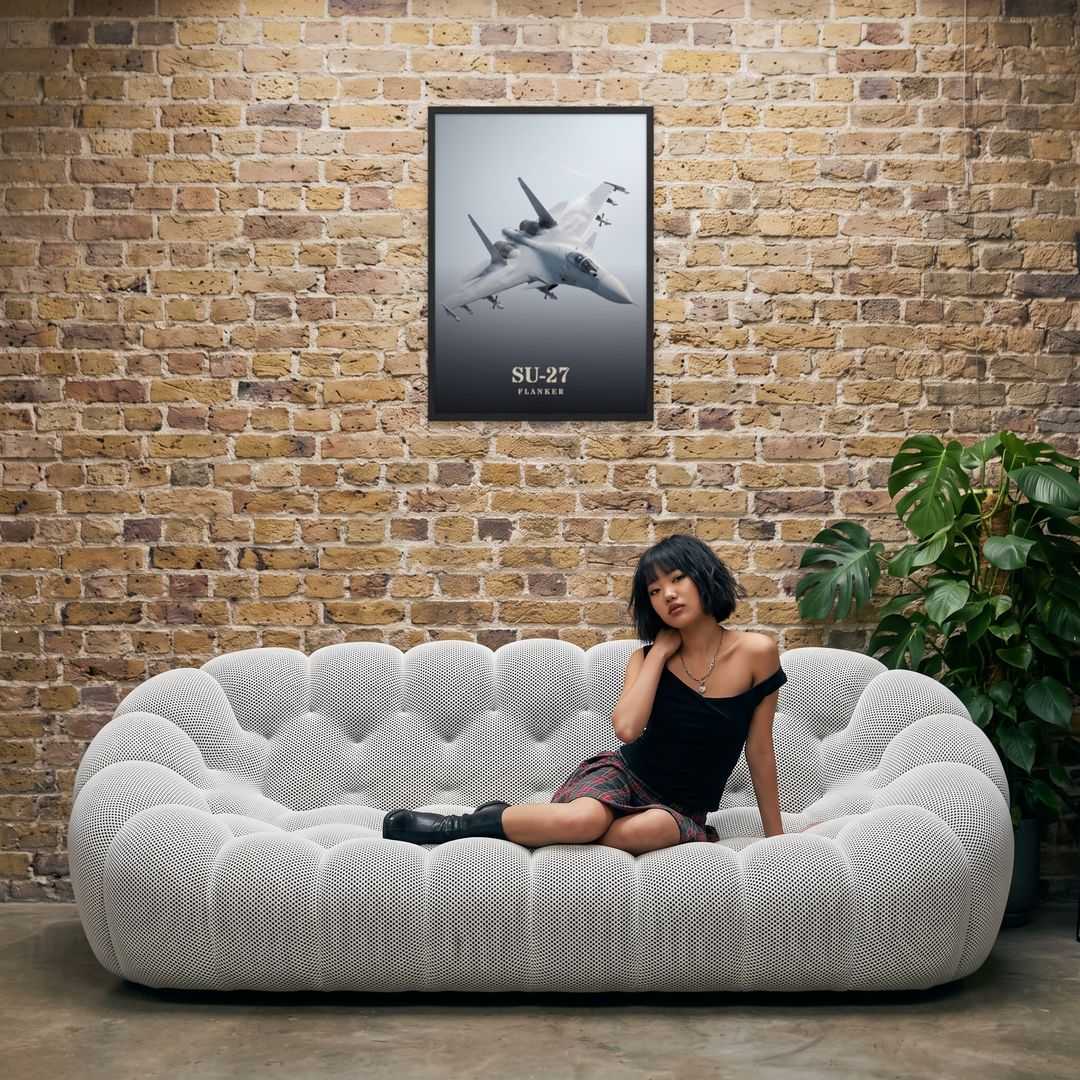 Su-27 Flanker, framed in black, in an industrial loft with tufted sofa