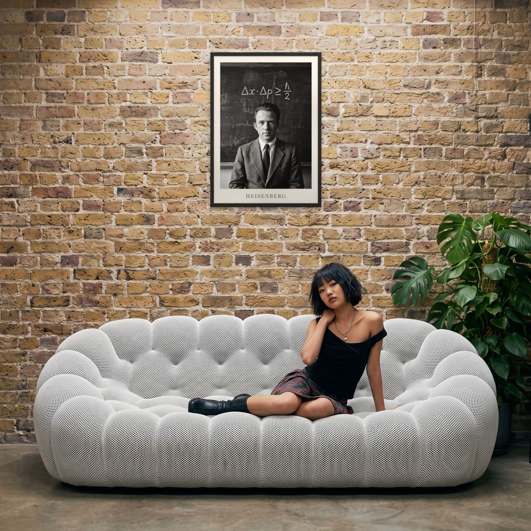 Werner Heisenberg, framed in black, in an industrial loft with tufted sofa