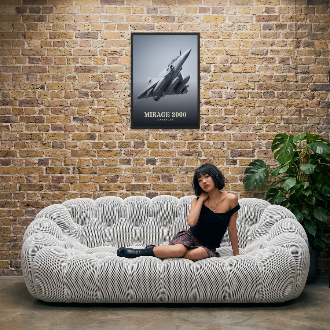 Mirage 2000, framed in black, in an industrial loft with tufted sofa