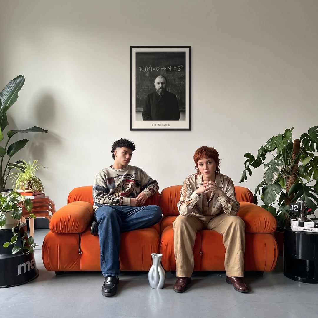 Henri Poincaré, framed in black, in a retro orange sofa lounge