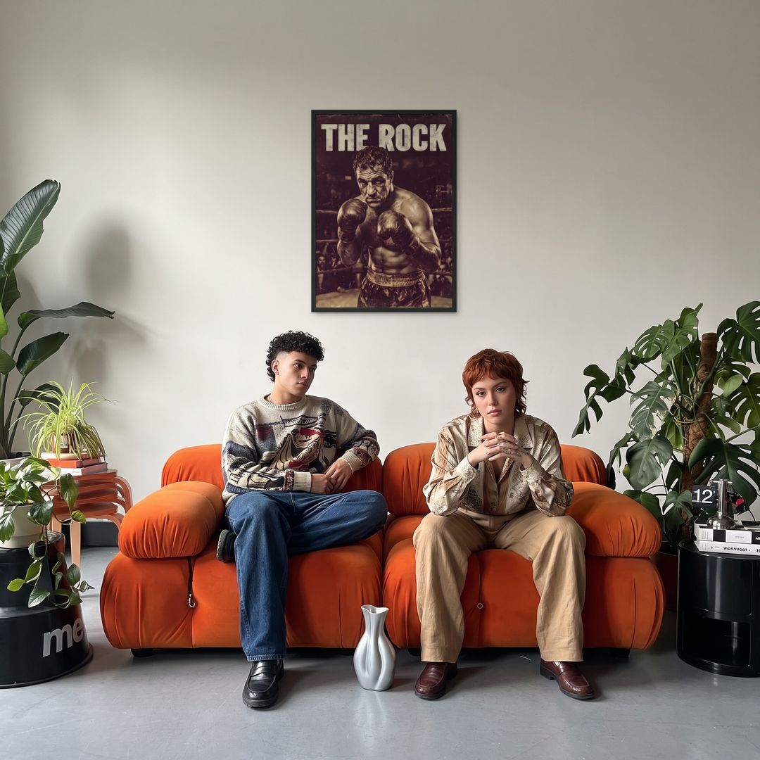 The Rock, framed in black, in a retro orange sofa lounge