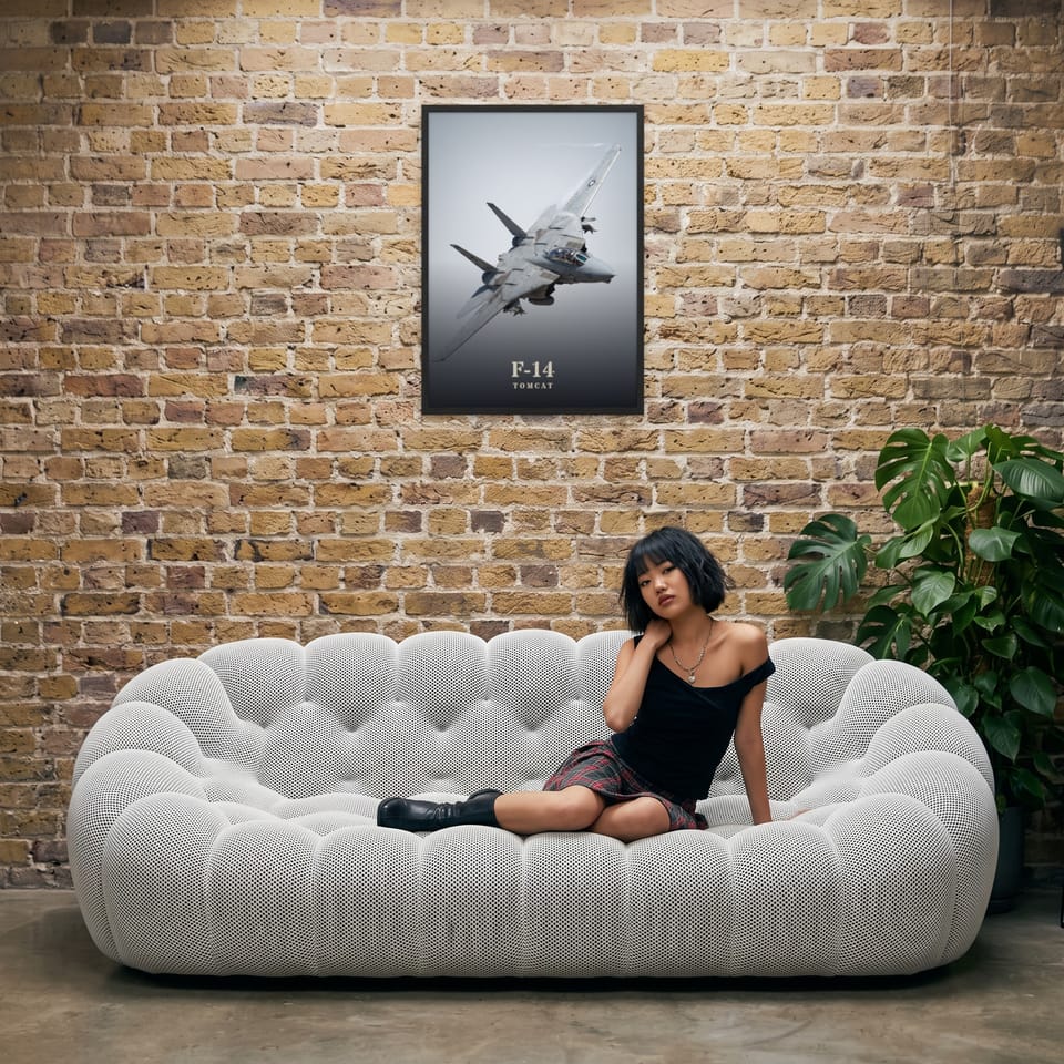 F-14 Tomcat, framed in black, in an industrial loft with tufted sofa