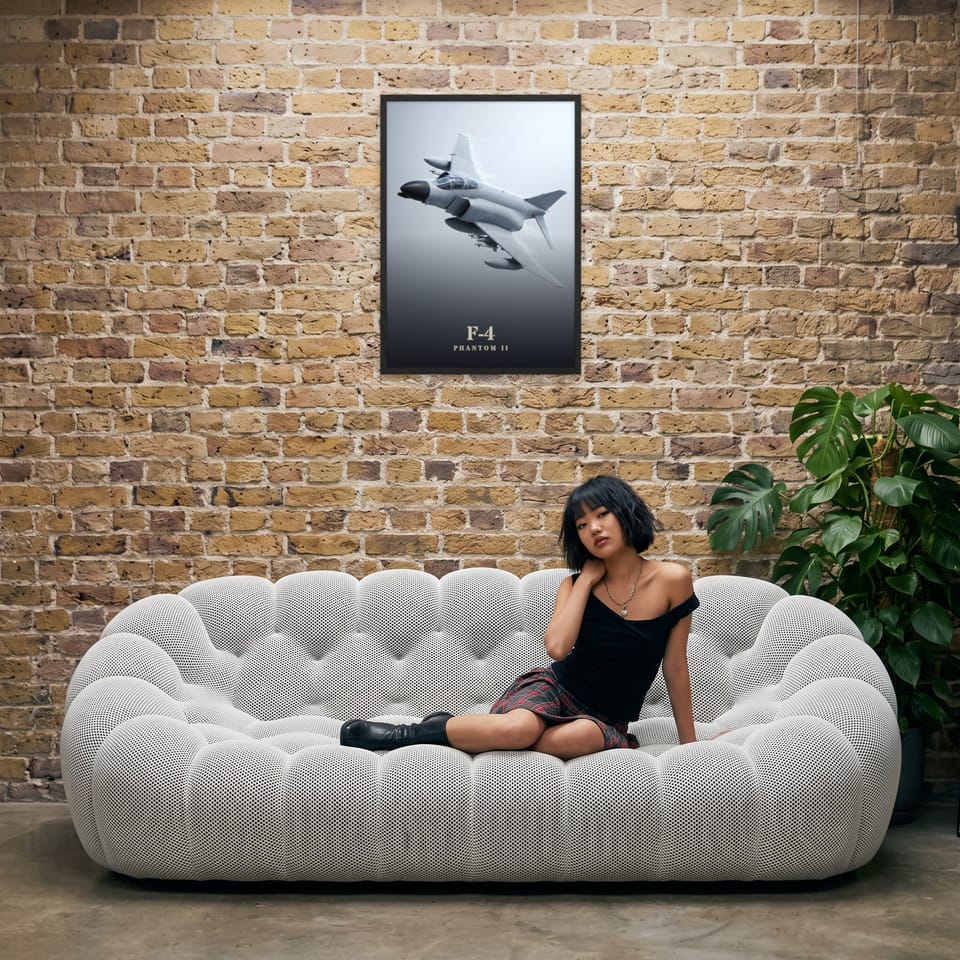 F-4 Phantom II, framed in black, in an industrial loft with tufted sofa